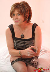 Libidinous crossdresser relaxing with a glass of