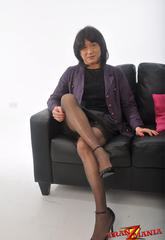 Lustful shemale in a skirt suit posing on the sofalustful
