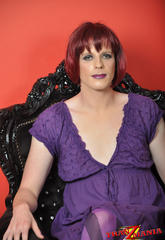 Libidinous shemale wearing a purple dress and posing on the